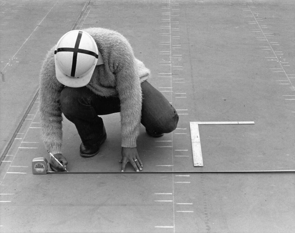 Inspector examining roof flashing and underlayment on a snow-ready residential roof.