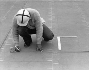 Inspector examining roof flashing and underlayment on a snow-ready residential roof.